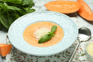 Photo of Delicious sweet potato soup served on white marble table, closeup
