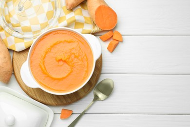 Photo of Delicious sweet potato soup served on white wooden table, flat lay. Space for text