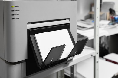 Photo of Modern printer with photo paper indoors, closeup. Printing house