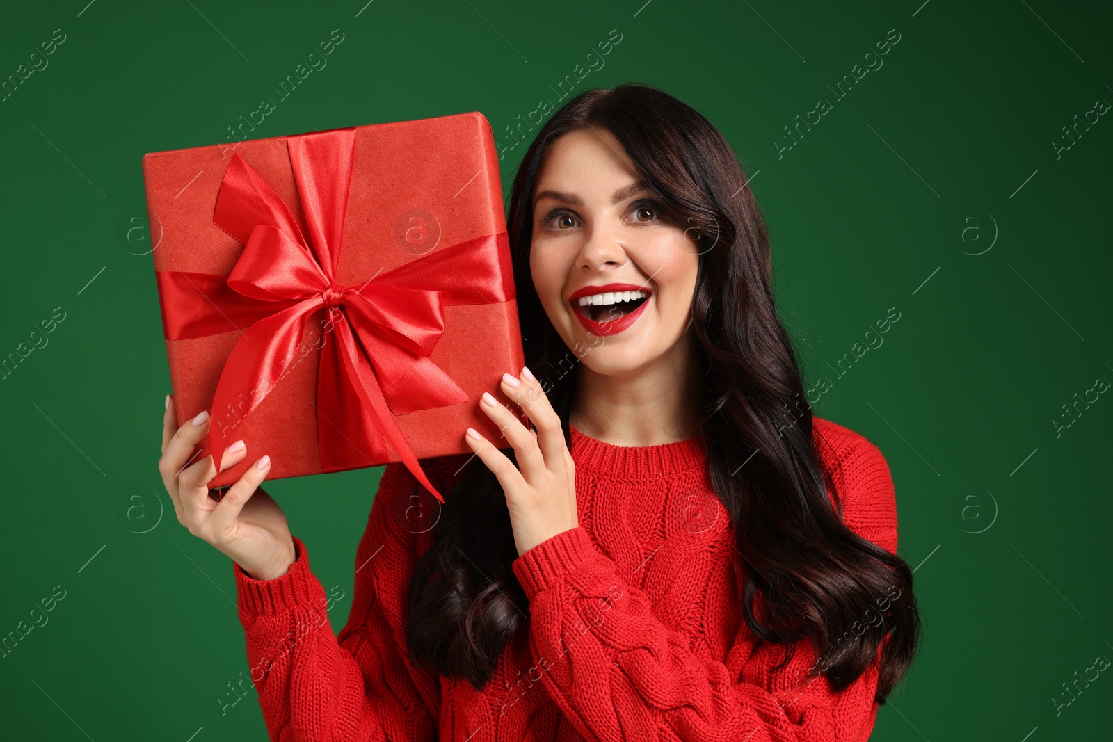 Photo of Beautiful woman with Christmas gift on green background