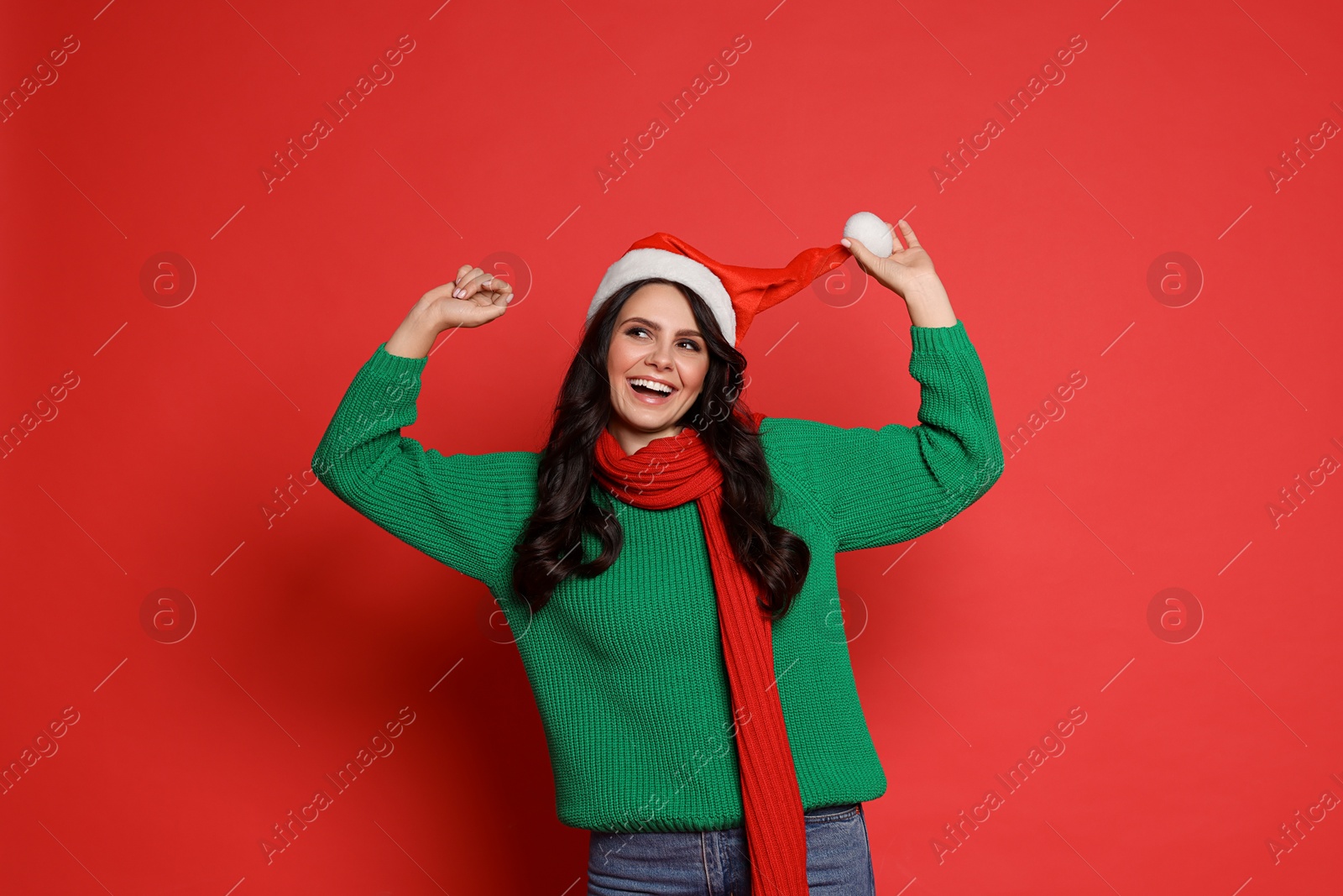 Photo of Beautiful woman in Santa hat on red background. Christmas celebration