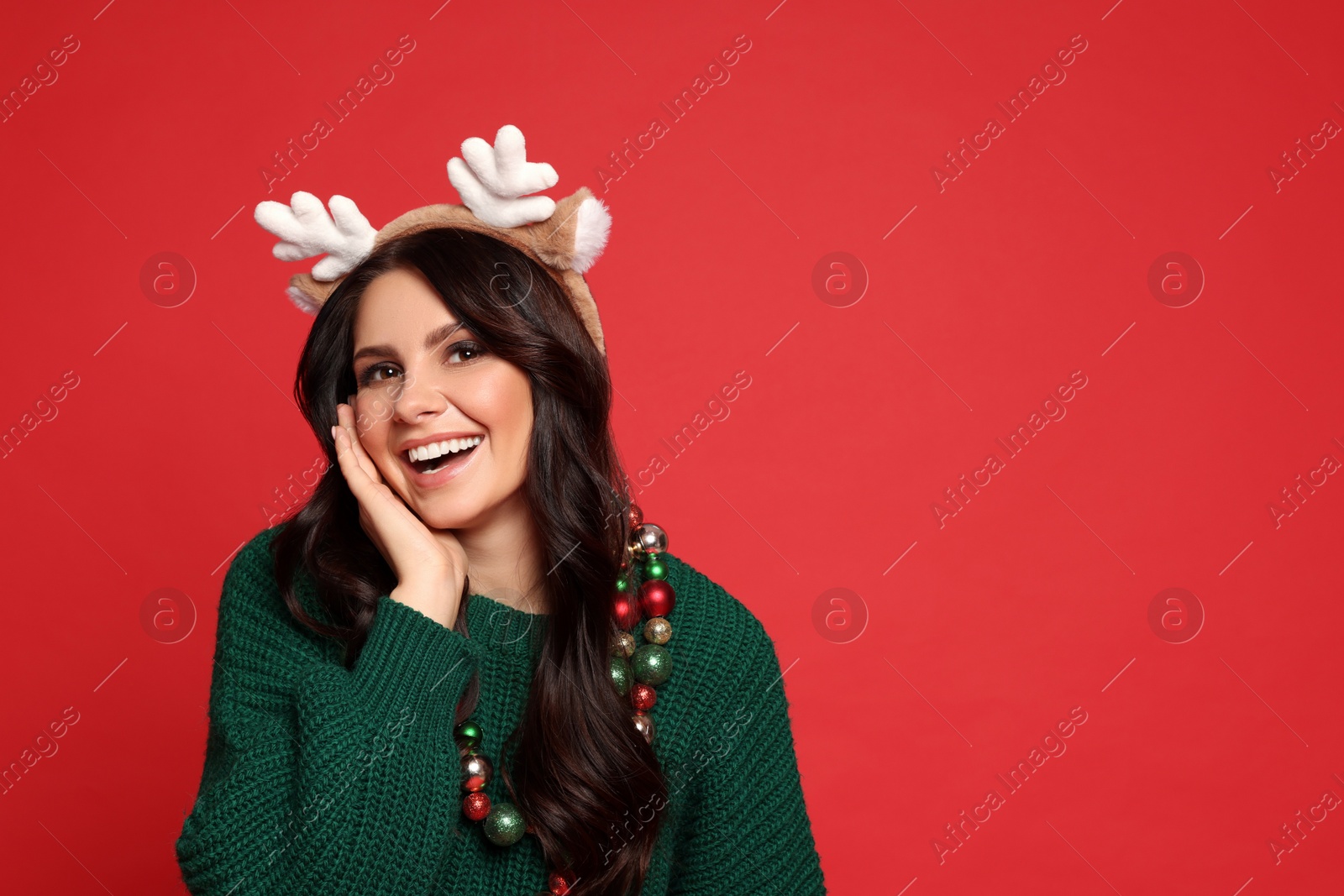 Photo of Beautiful woman with Christmas accessories on red background, space for text