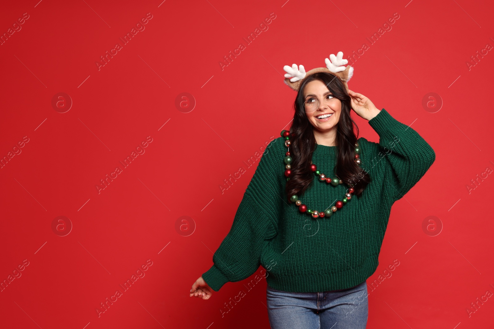 Photo of Beautiful woman with Christmas accessories on red background, space for text