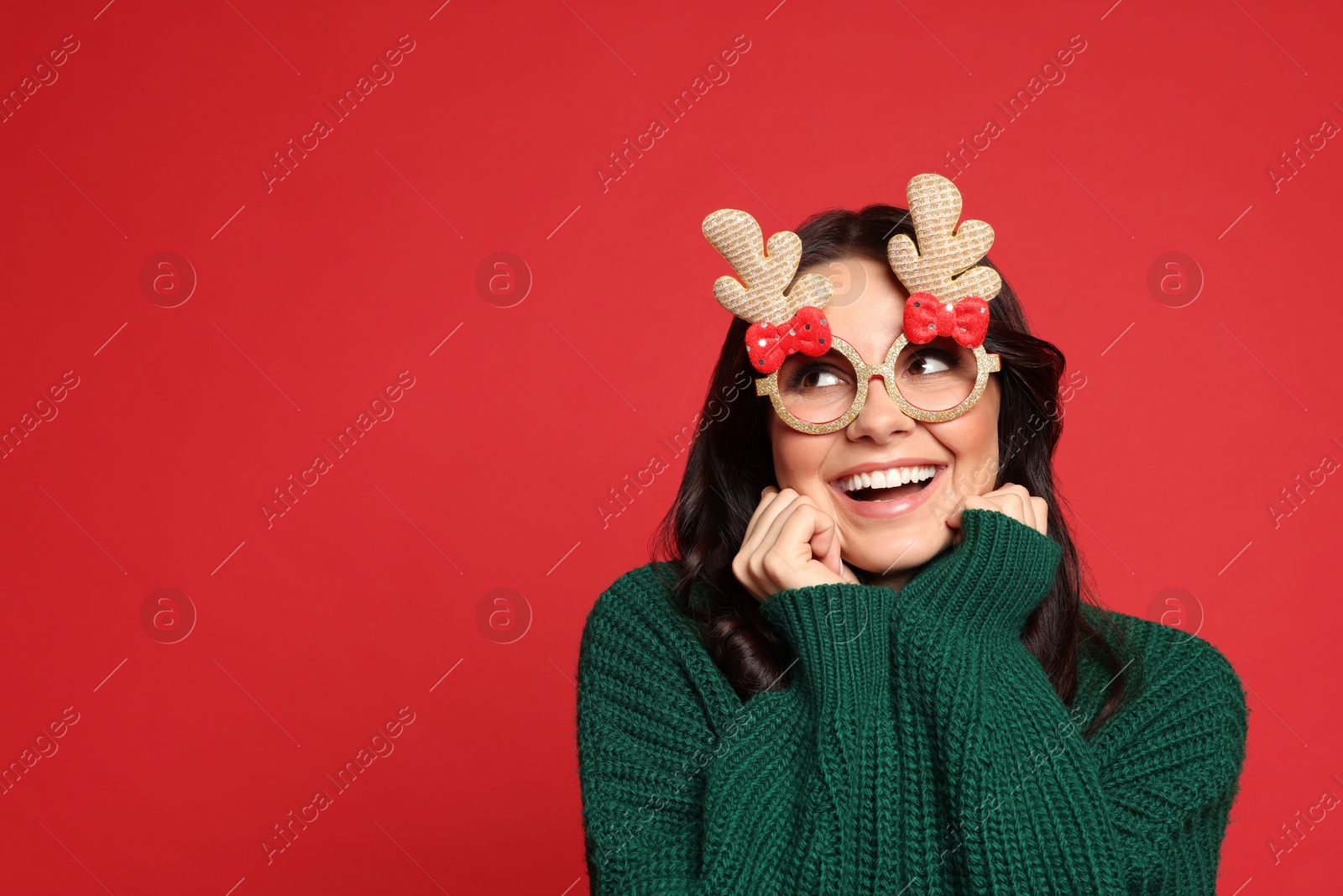 Photo of Happy woman with party glasses on red background. Christmas celebration, space for text