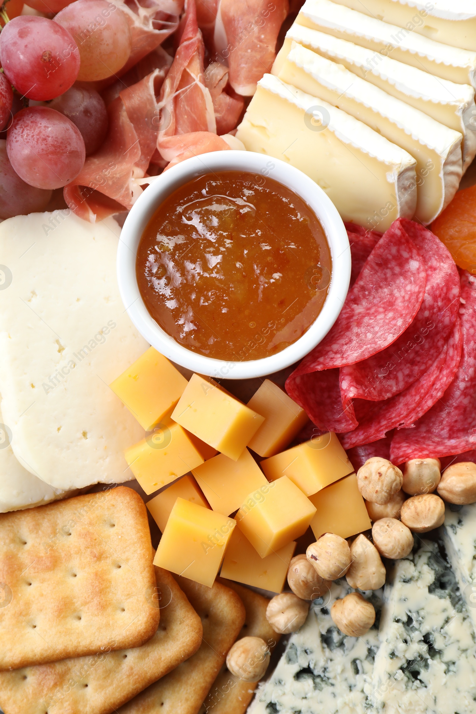 Photo of Different types of cut cheese and other snacks, top view