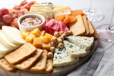 Photo of Different types of cut cheese and other snacks on table, closeup