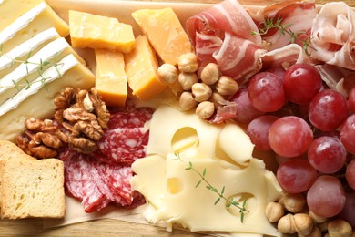 Photo of Different types of cut cheese and other snacks on table, top view