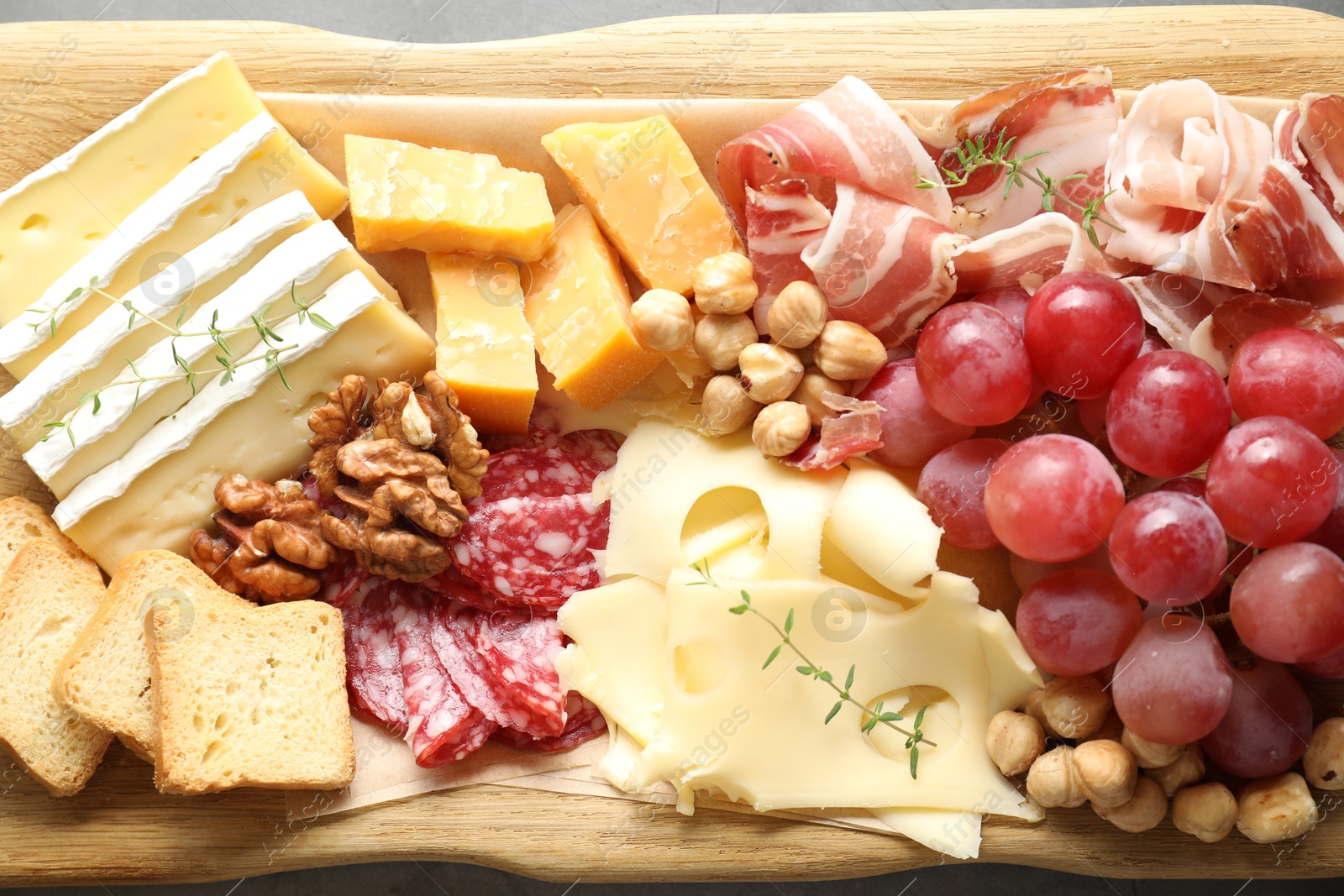 Photo of Different types of cut cheese and other snacks on table, top view