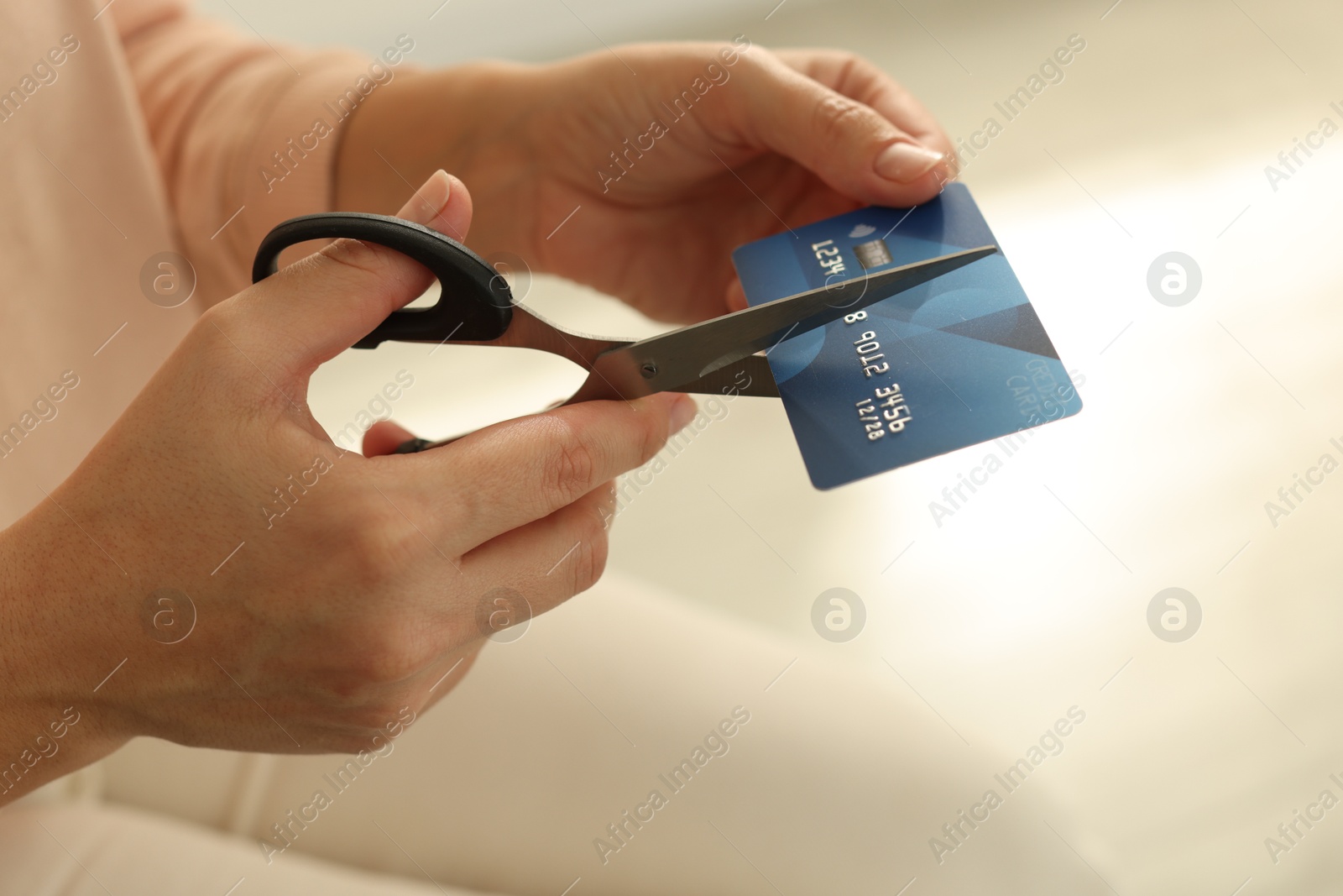 Photo of Woman cutting plastic credit card indoors, closeup