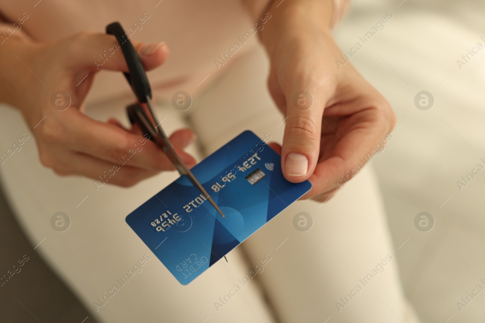 Photo of Woman cutting plastic credit card indoors, closeup