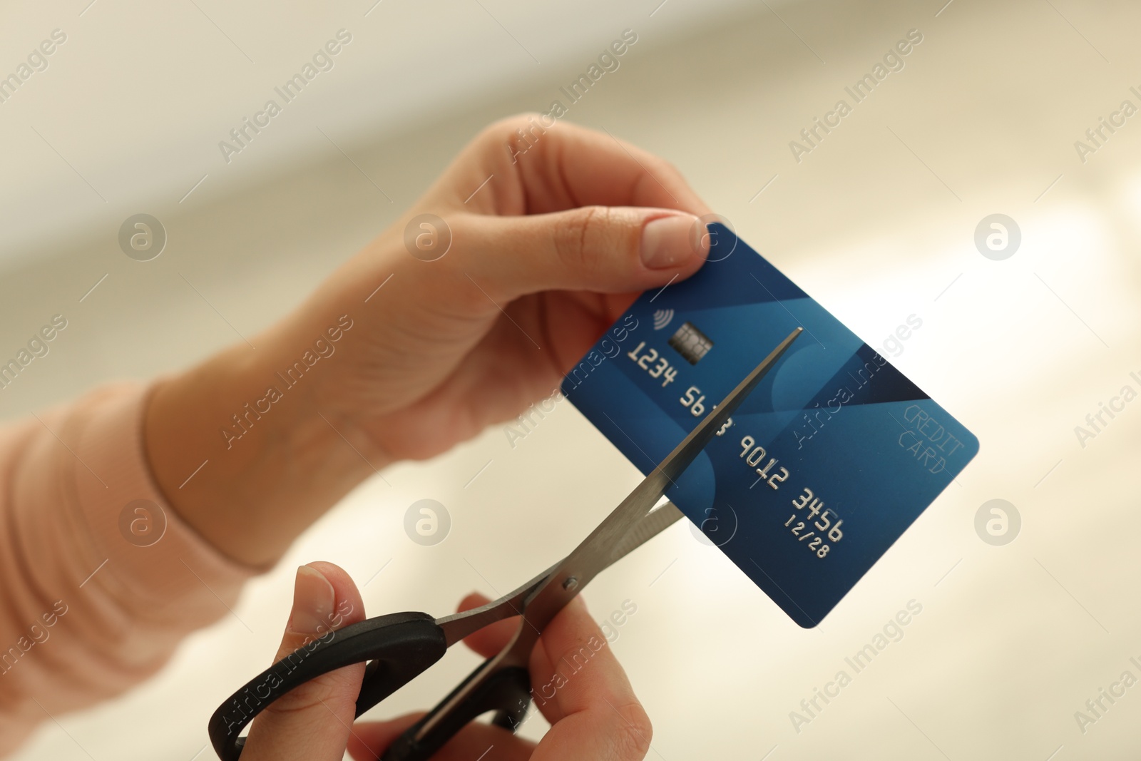 Photo of Woman cutting plastic credit card indoors, closeup