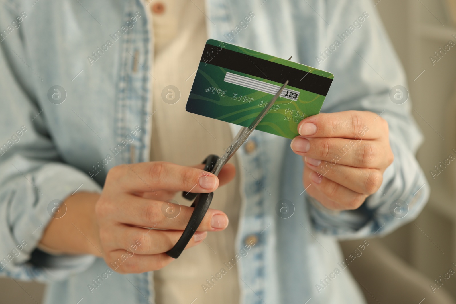 Photo of Woman cutting plastic credit card indoors, closeup