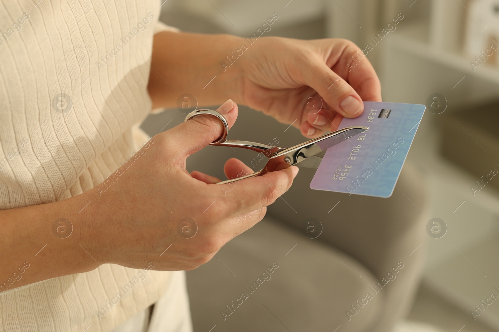 Photo of Woman cutting plastic credit card indoors, closeup