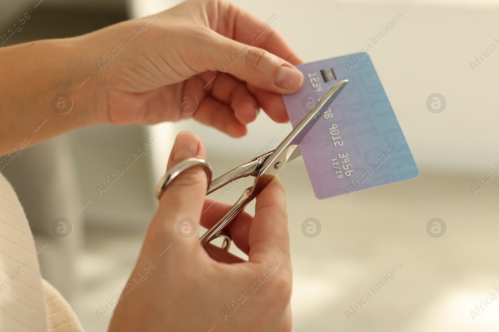 Photo of Woman cutting plastic credit card indoors, closeup