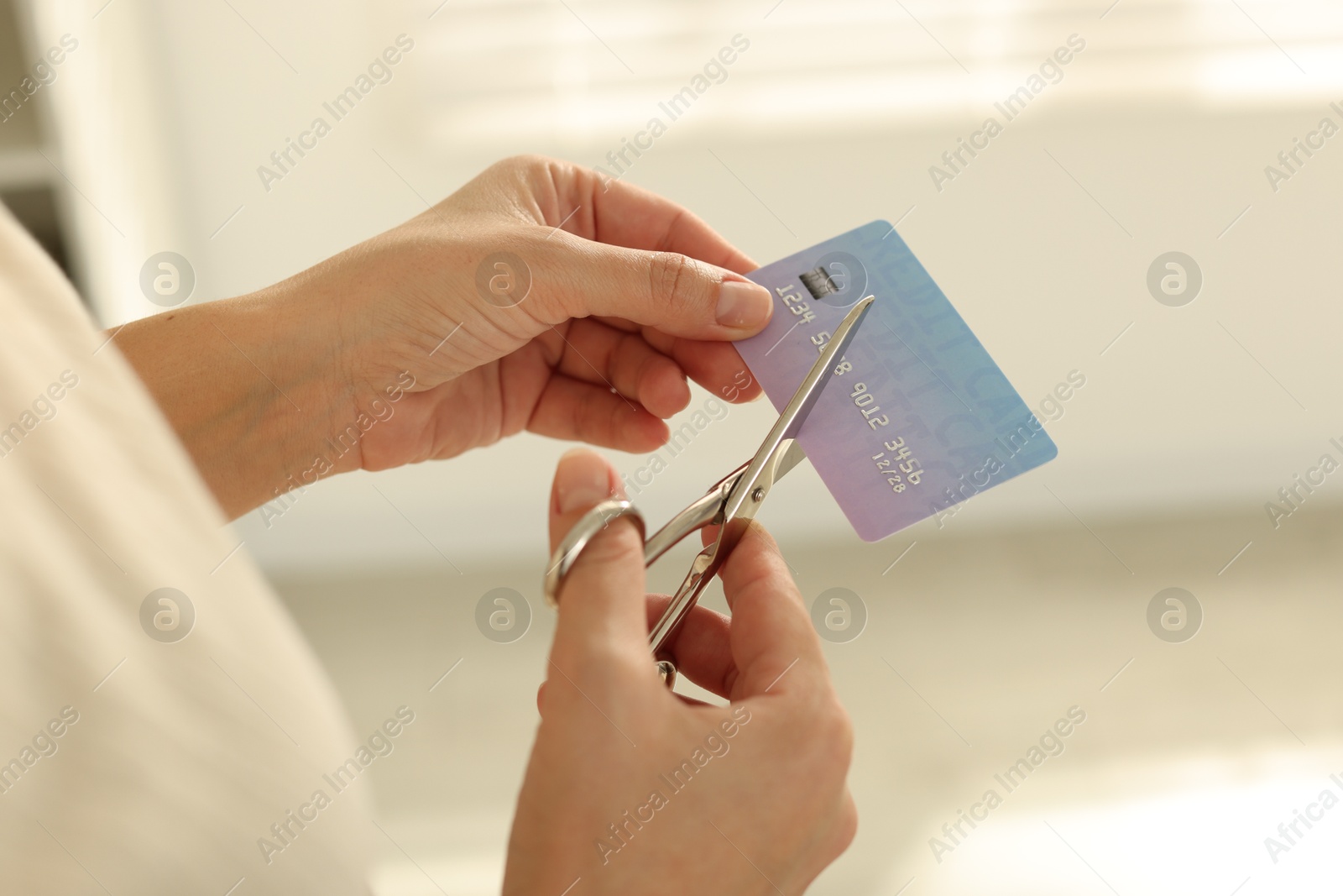 Photo of Woman cutting plastic credit card indoors, closeup