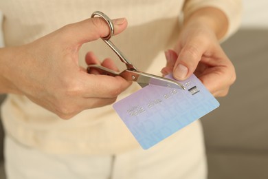 Photo of Woman cutting plastic credit card indoors, closeup