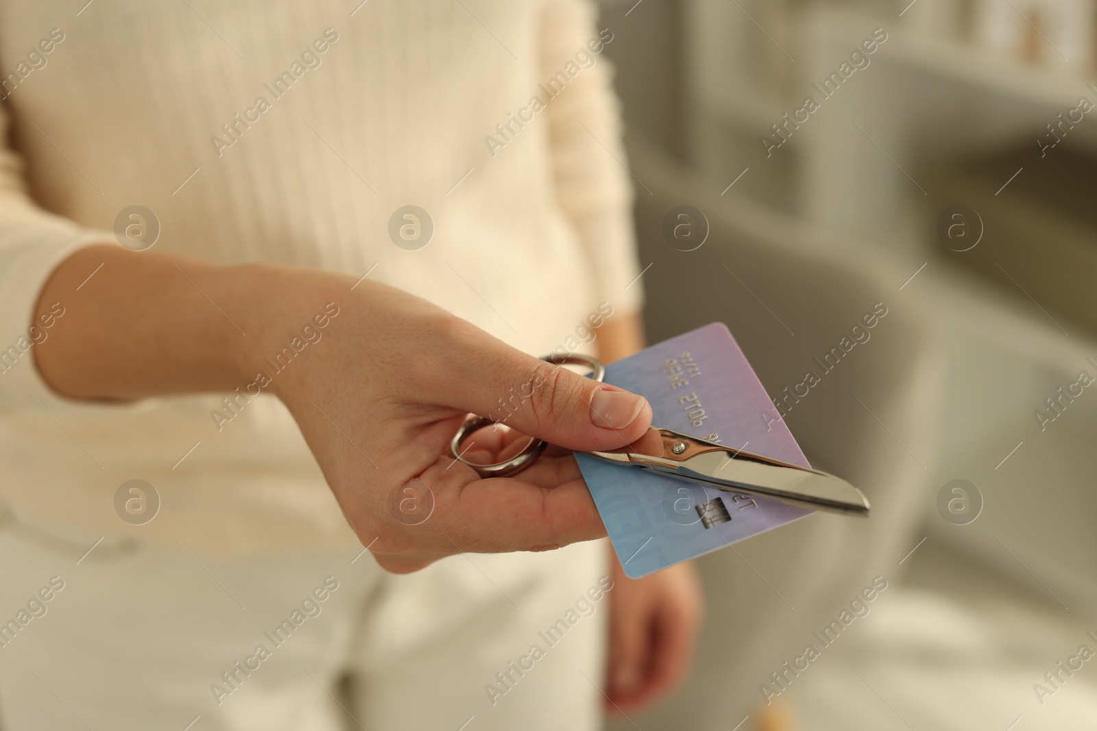 Photo of Woman with credit card and scissors indoors, closeup