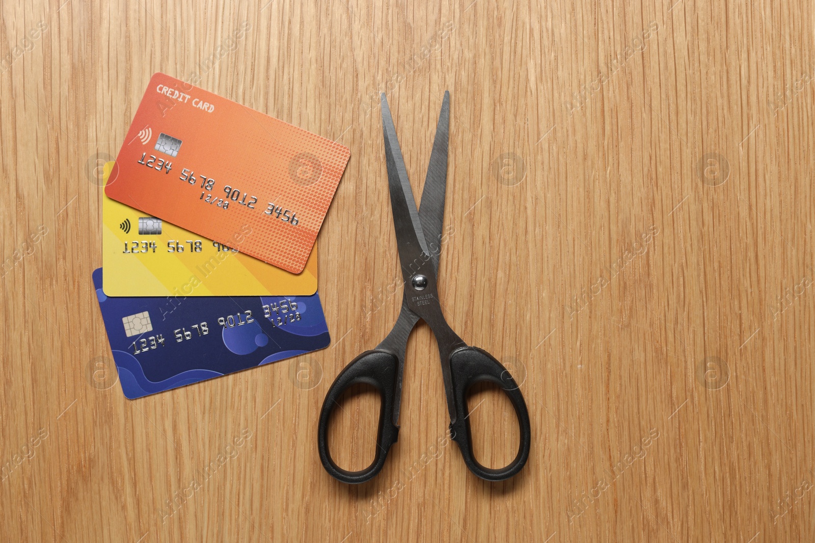 Photo of Credit cards and scissors on wooden table, top view