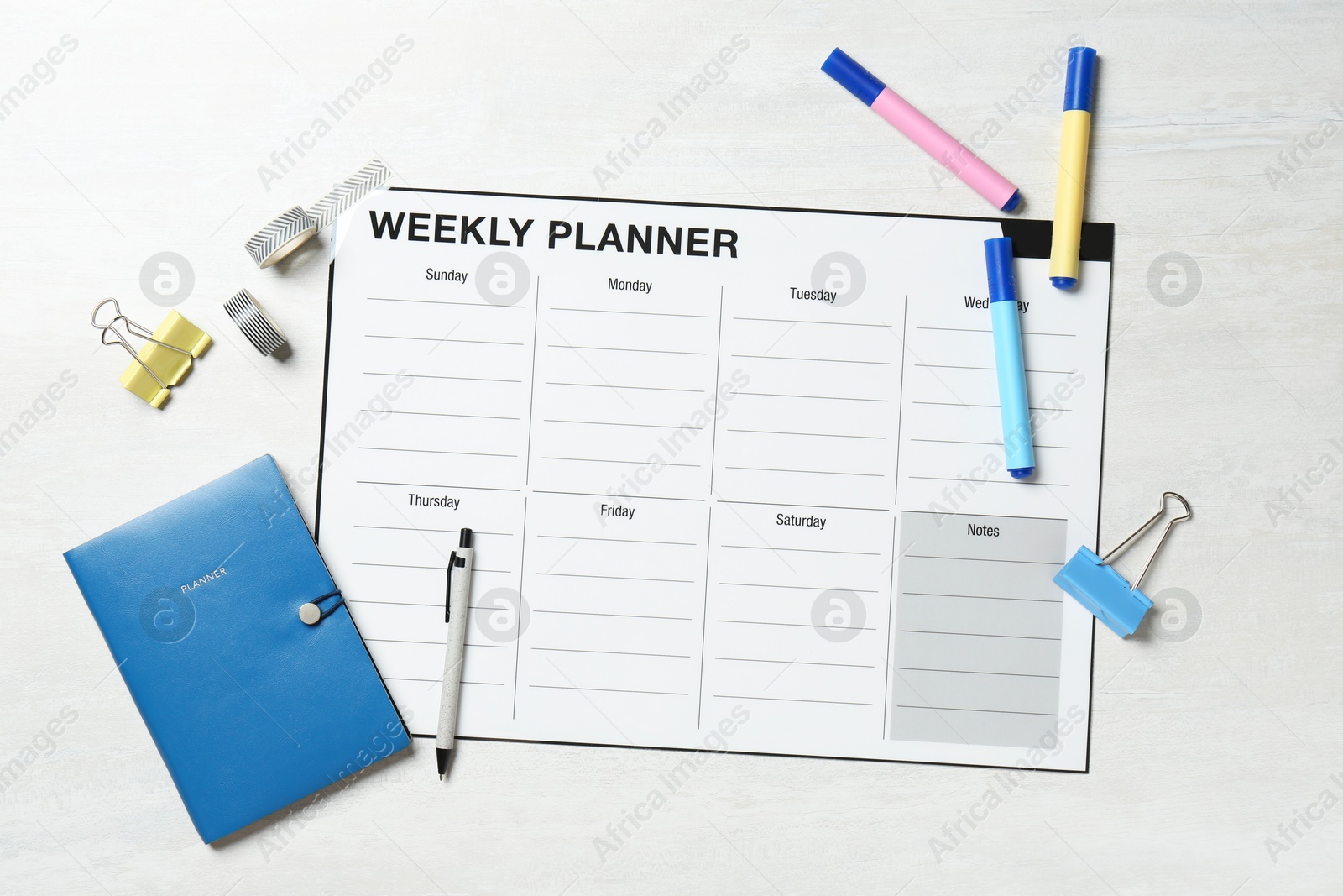 Photo of Timetable. Weekly planner and stationery on white wooden table, flat lay