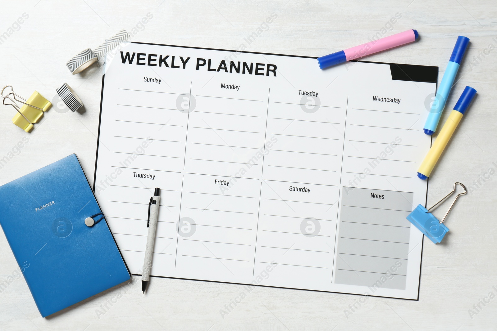 Photo of Timetable. Weekly planner and stationery on white wooden table, flat lay