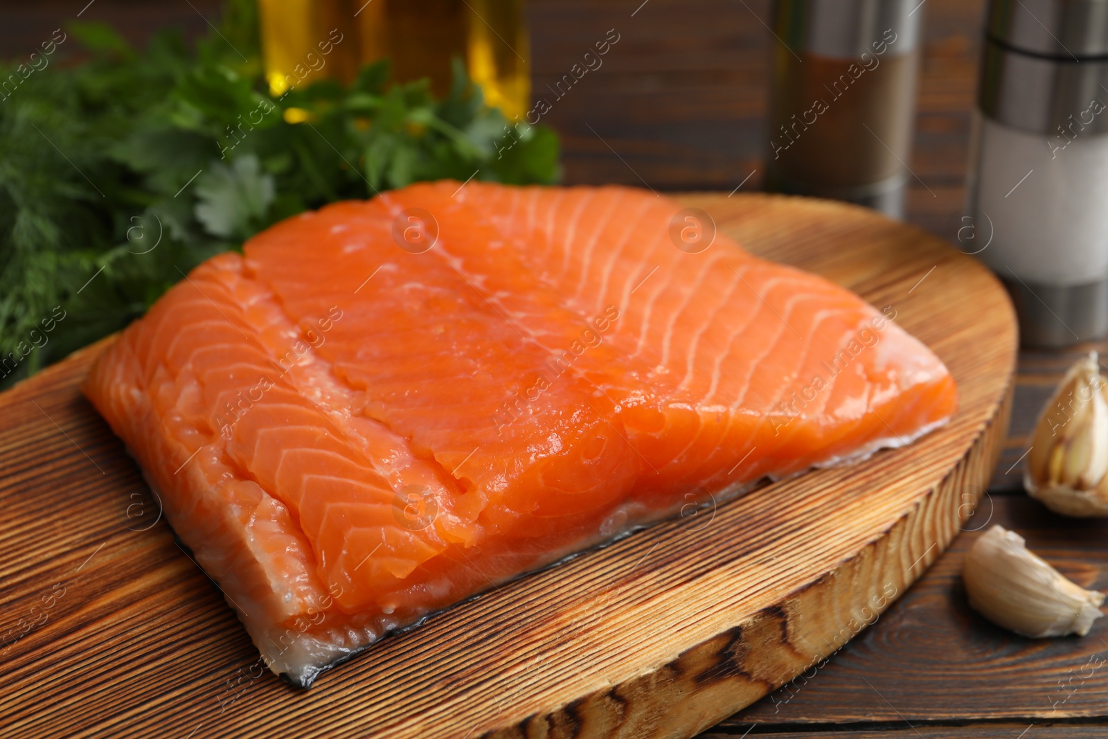 Photo of Salmon fillet and spices on wooden table, closeup