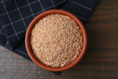 Photo of Buckwheat bran in bowl on wooden table, top view