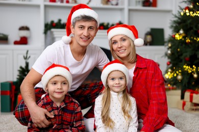 Portrait of happy family in Santa hats at home. Christmas holidays