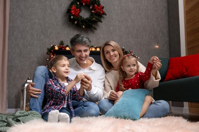 Lovely family with Christmas sparklers at home