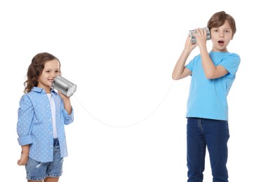 Photo of Boy and girl talking on tin can telephone against white background