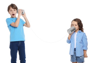 Boy and girl talking on tin can telephone against white background