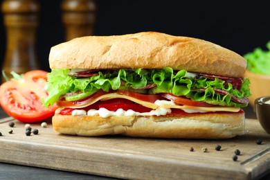 Photo of Delicious baguette sandwich with salami and cheese on table, closeup