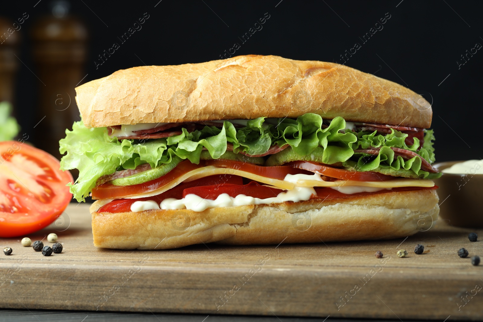 Photo of Delicious baguette sandwich with salami and cheese on table, closeup