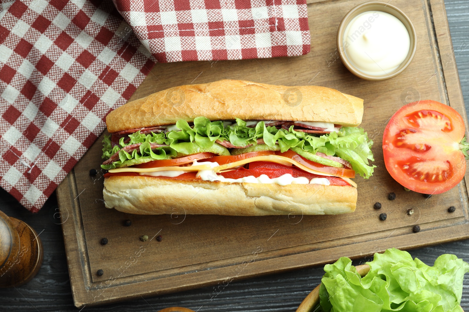 Photo of Delicious baguette sandwich with salami and cheese on table, flat lay