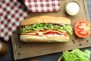 Photo of Delicious baguette sandwich with salami and cheese on table, flat lay