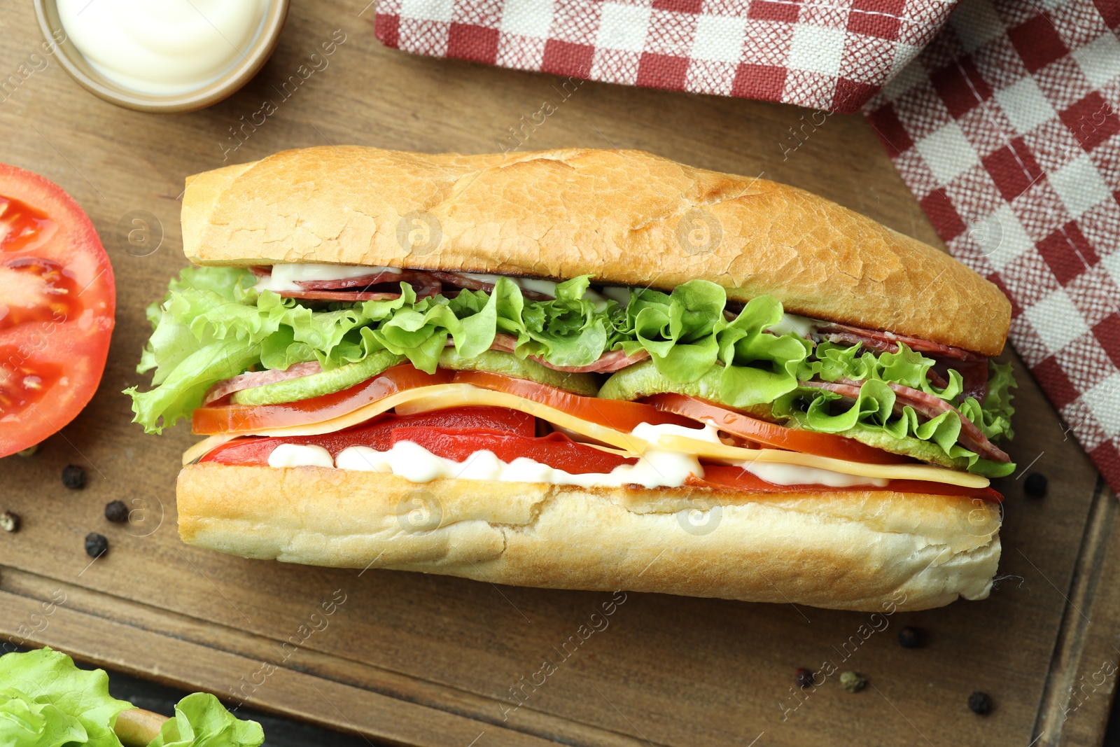 Photo of Delicious baguette sandwich with salami and cheese on table, flat lay