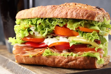 Photo of Delicious baguette sandwich with tomatoes and yellow beans on table, closeup