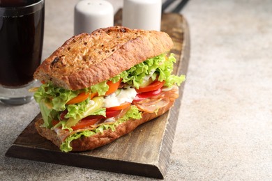 Photo of Delicious baguette sandwich with tomatoes and yellow beans on grey textured table, closeup