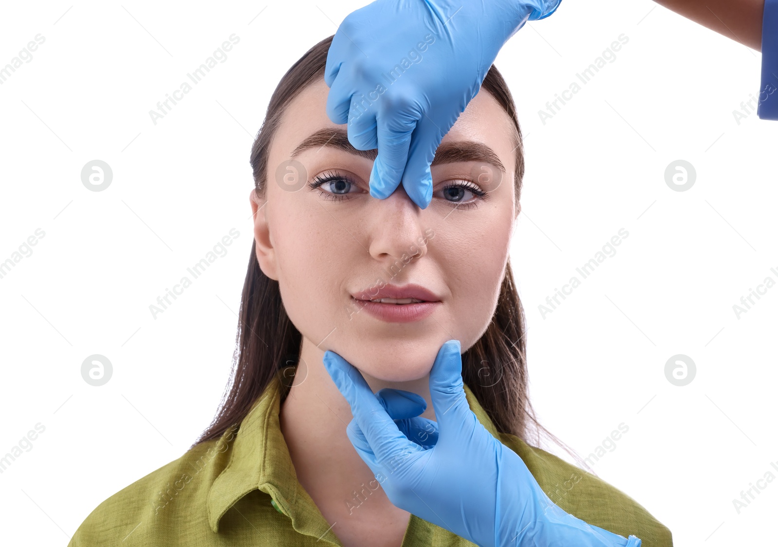 Photo of Doctor checking patient's nose before plastic surgery operation on white background, closeup