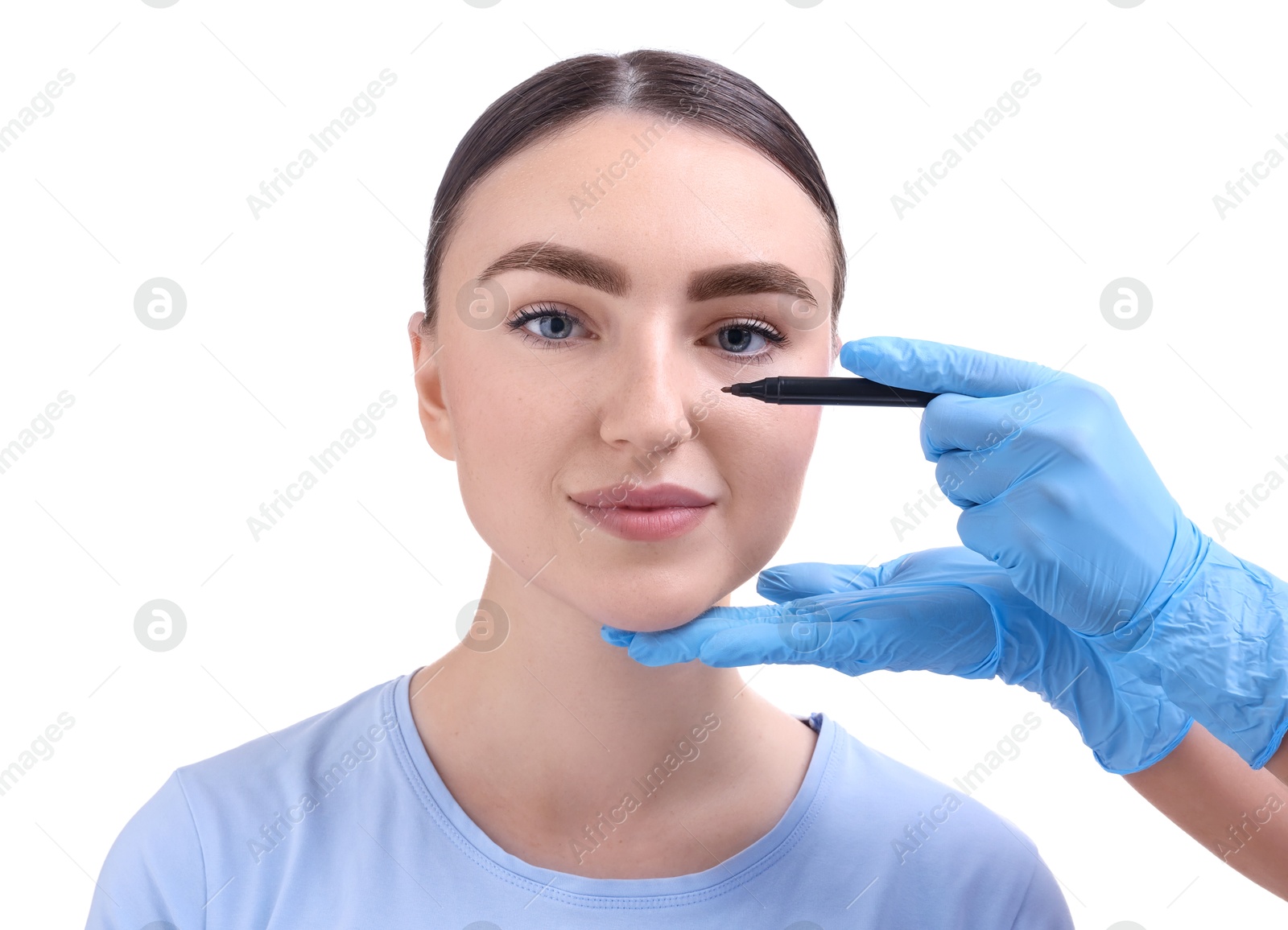 Photo of Doctor drawing marks on patient's nose for plastic surgery operation against white background, closeup