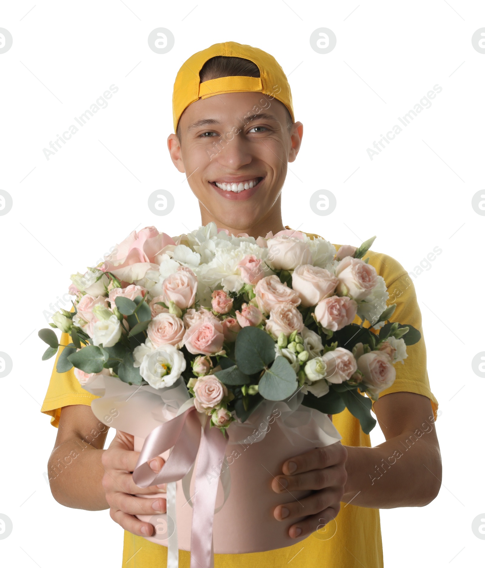 Photo of Smiling delivery man holding gift box with beautiful floral composition on white background