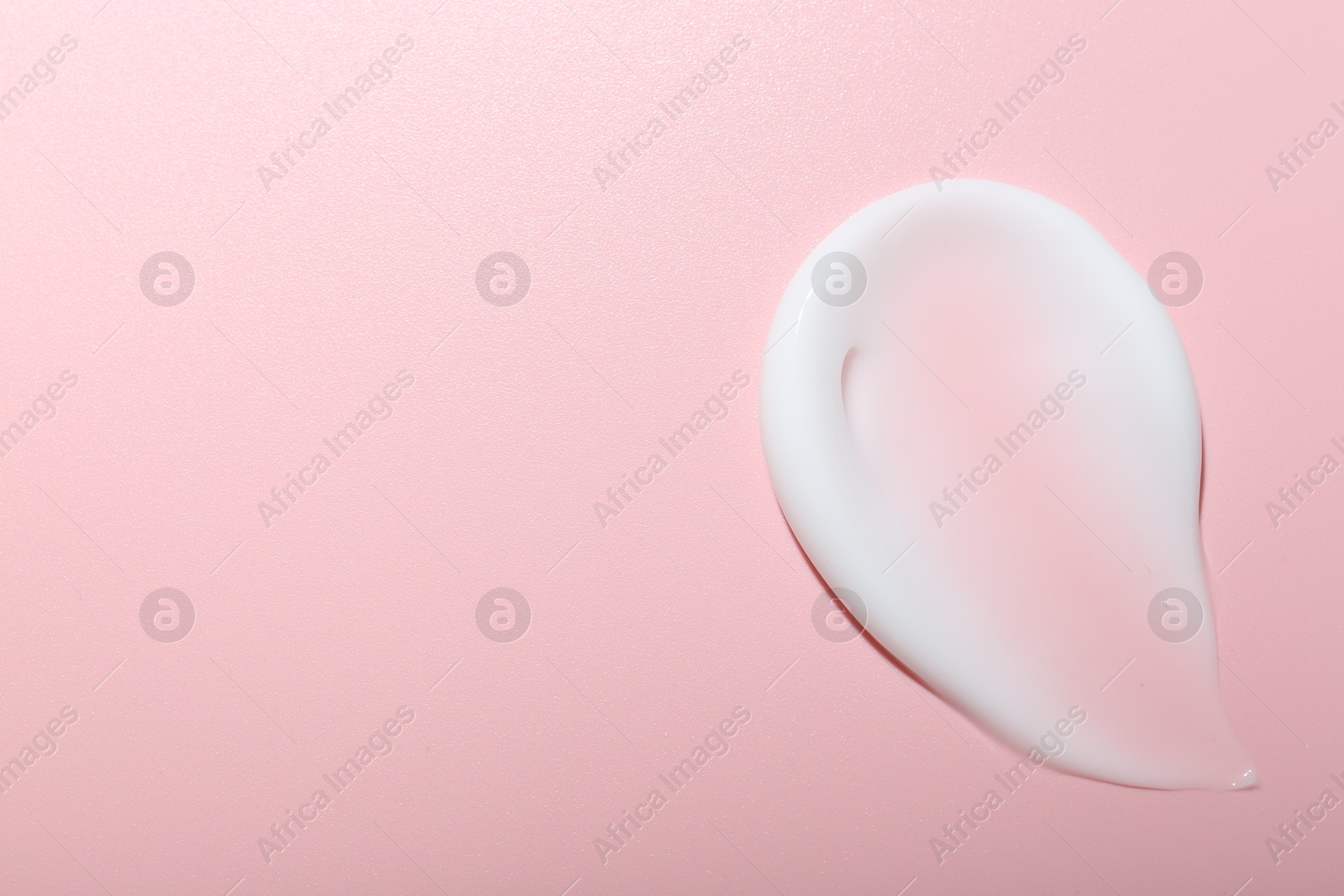 Photo of Cream sample on pink background, top view. Space for text