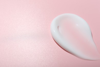 Photo of Cream sample on pink background, closeup. Space for text