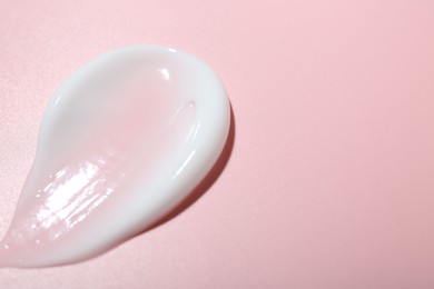 Photo of Cream sample on pink background, closeup. Space for text