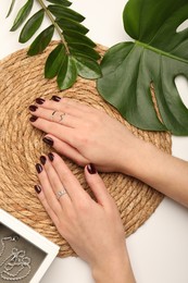 Photo of Woman wearing beautiful rings at white table, top view