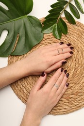 Photo of Woman wearing beautiful rings at white table, top view