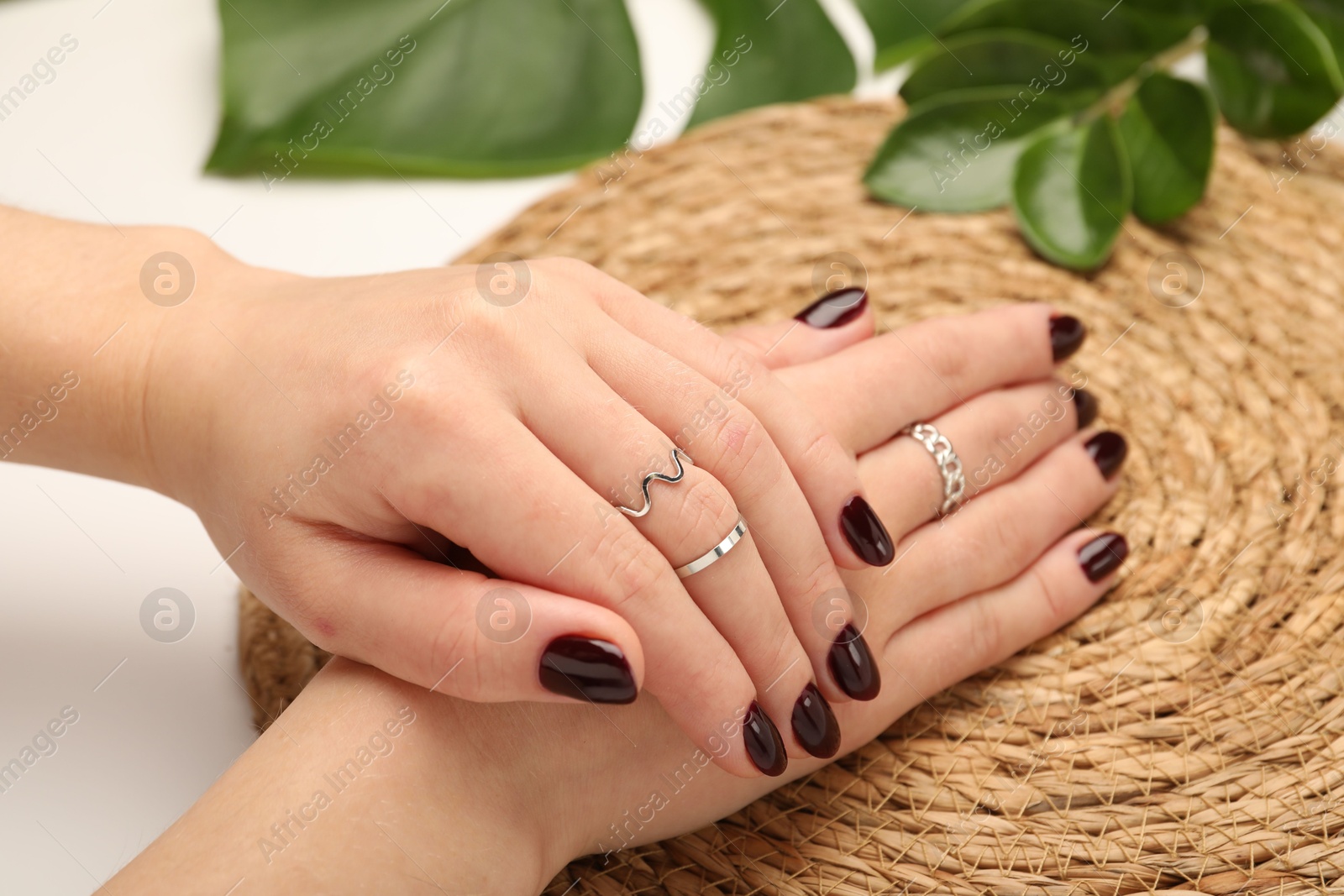 Photo of Woman wearing beautiful rings at white table, closeup