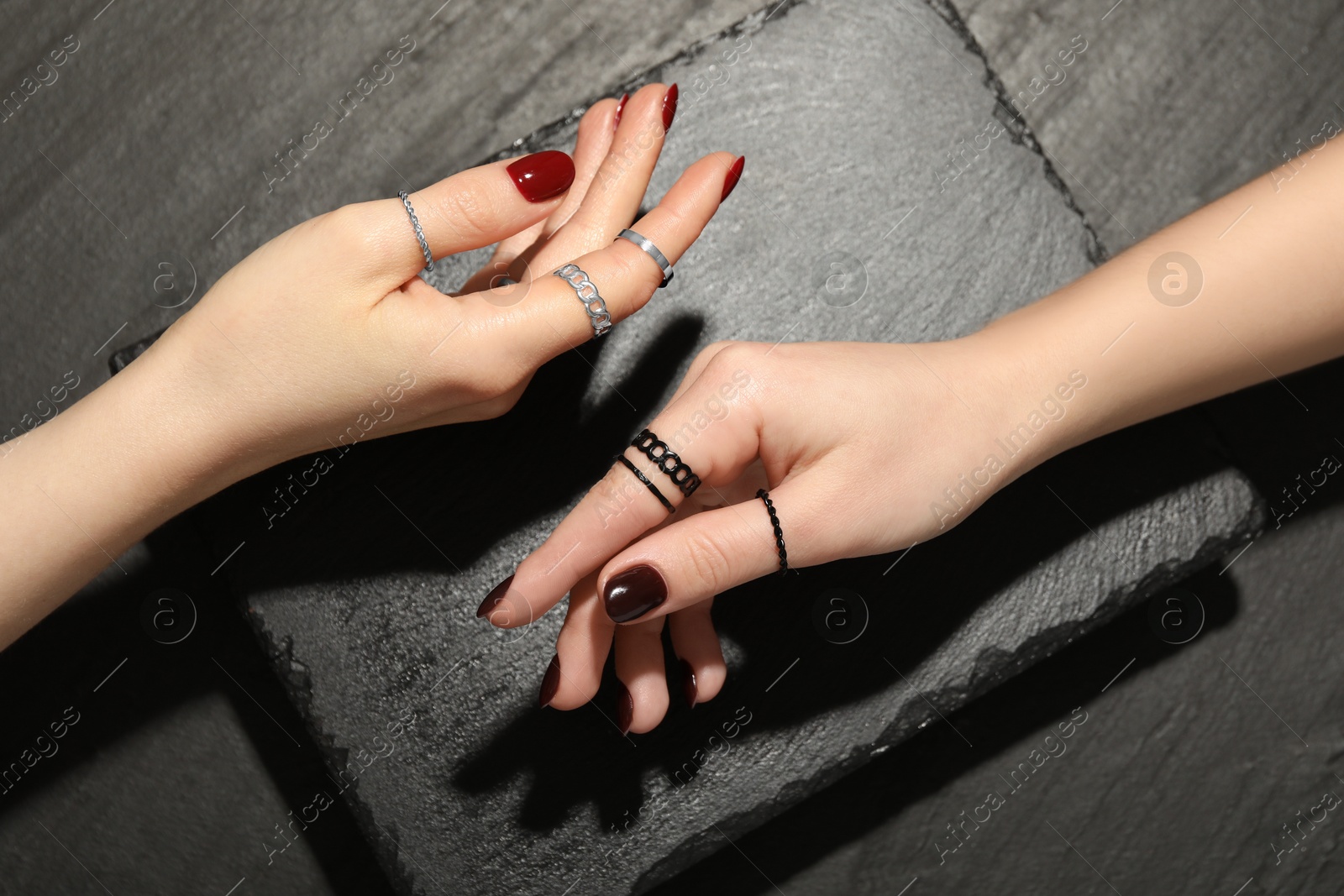 Photo of Women wearing beautiful rings on black background, closeup