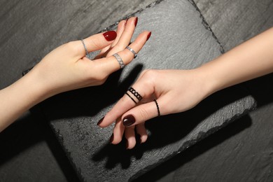 Women wearing beautiful rings on black background, closeup