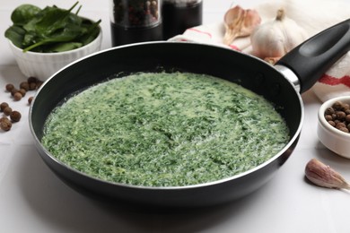 Delicious spinach sauce served on white tiled table, closeup