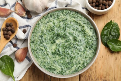 Photo of Delicious spinach sauce served on wooden table, flat lay